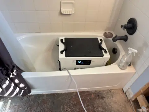 Compact dehumidifier set in a bathtub to dry a bathroom