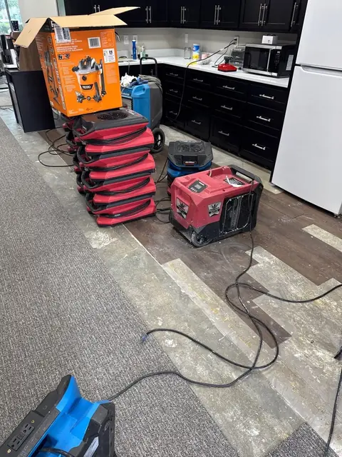 Stacked air movers, a dehumidifier and an extractor staged in an office kitchen