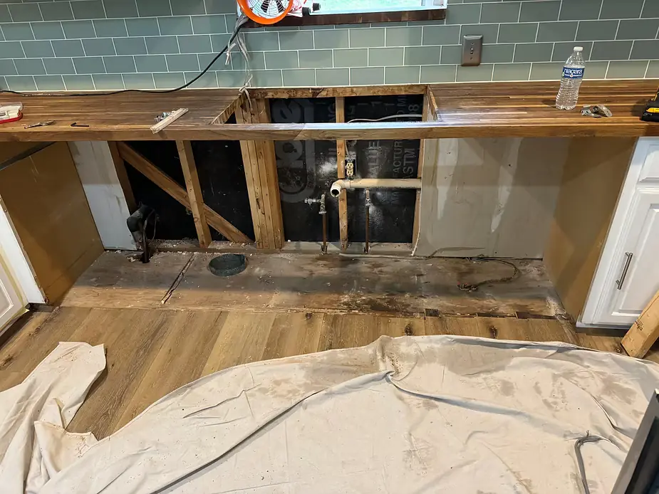 Kitchen with lower cabinets removed and wall opened after a water leak