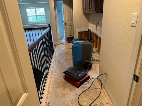 Dehumidifier and air mover on an upstairs landing with the carpet removed