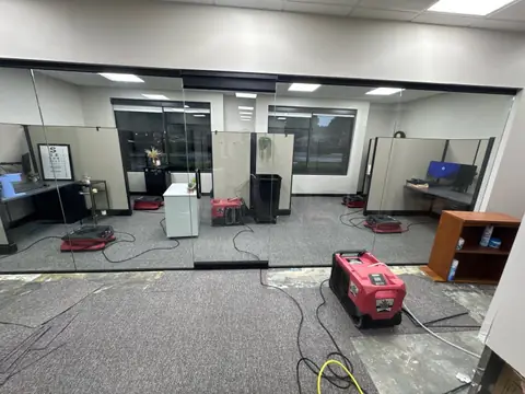 Open-plan office with flood cuts along the walls and drying equipment running