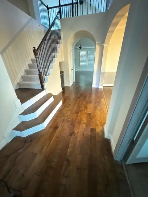 Entry hall with new wood floors leading to the staircase