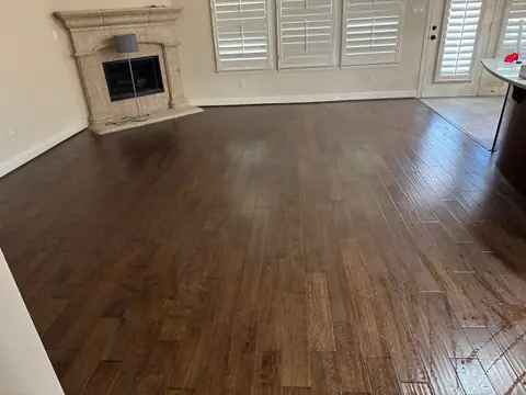 Living room with new wood floors and a stone fireplace