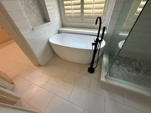 Finished bathroom with a freestanding tub, glass shower and new tile floor