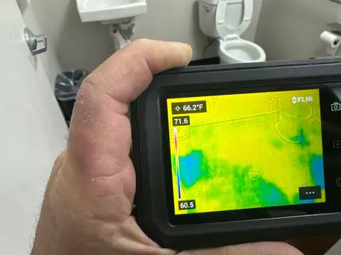 Thermal camera checking a bathroom wall for moisture