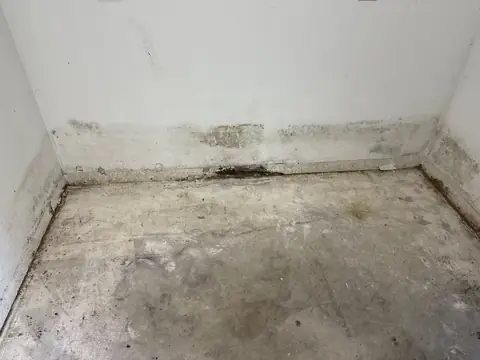 Empty room with baseboards removed and water staining along the wall